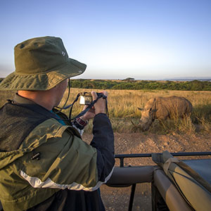 Wildlife photographer capturing close-up of rhino during safari photography tour